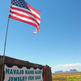 Monument Valley. Highway 163 - Monument Valley. - Fahne, Star-Spangled Banner, Monument Valley, Navajo-Nation-Reservation, Tafelberge, Landschaft, Verkaufsstand, Tribal Park, Highway 163, Stars and Stripes - (Halchita, Mexican Hat, Utah, Vereinigte Staaten)