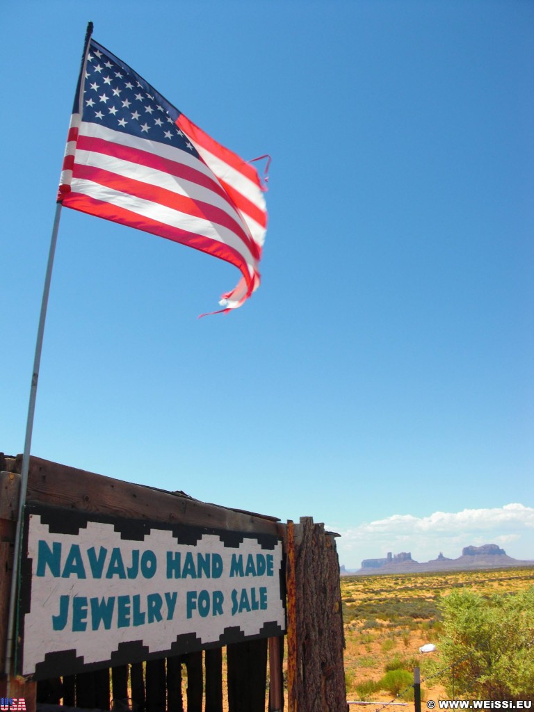 Monument Valley. Highway 163 - Monument Valley. - Fahne, Star-Spangled Banner, Monument Valley, Navajo-Nation-Reservation, Tafelberge, Landschaft, Verkaufsstand, Tribal Park, Highway 163, Stars and Stripes - (Halchita, Mexican Hat, Utah, Vereinigte Staaten)