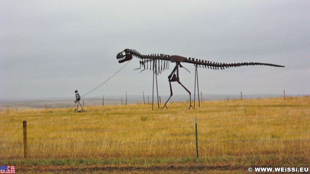 On the Road. Gassi gehen mal anders.... - Skulptur, Statue, Skulpturen, Figuren, Dino, Dinosaurier, Skelett, Tyrannosaurus rex, Midland, Stamford, Metallfiguren, T-Rex, Clarence Hullinger, Altmetall - (Stamford, Midland, South Dakota, Vereinigte Staaten)