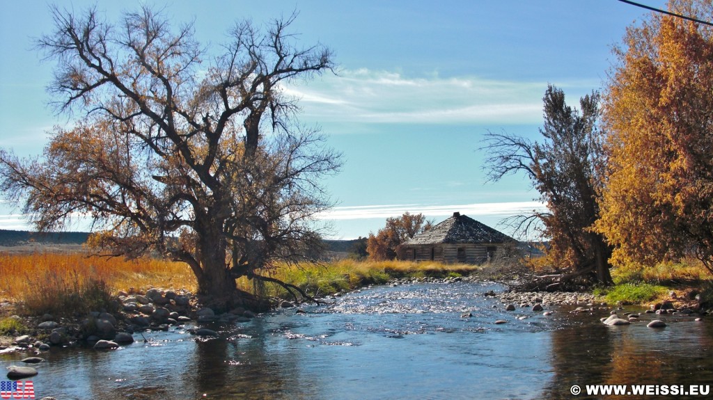 On the Road. Ten Sleep Creek - On the Road. - Gebäude, Haus, Landschaft, Bäume, Hütte, Fluss, Steine, Holzhaus, US Route 16, Bighorn Basin, Ten Sleep Creek, Bach, Holzhütte - (Ten Sleep, Wyoming, Vereinigte Staaten)