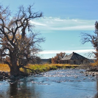 On the Road. Ten Sleep Creek - On the Road. - Gebäude, Haus, Landschaft, Bäume, Hütte, Fluss, Steine, Holzhaus, US Route 16, Bighorn Basin, Ten Sleep Creek, Bach, Holzhütte - (Ten Sleep, Wyoming, Vereinigte Staaten)