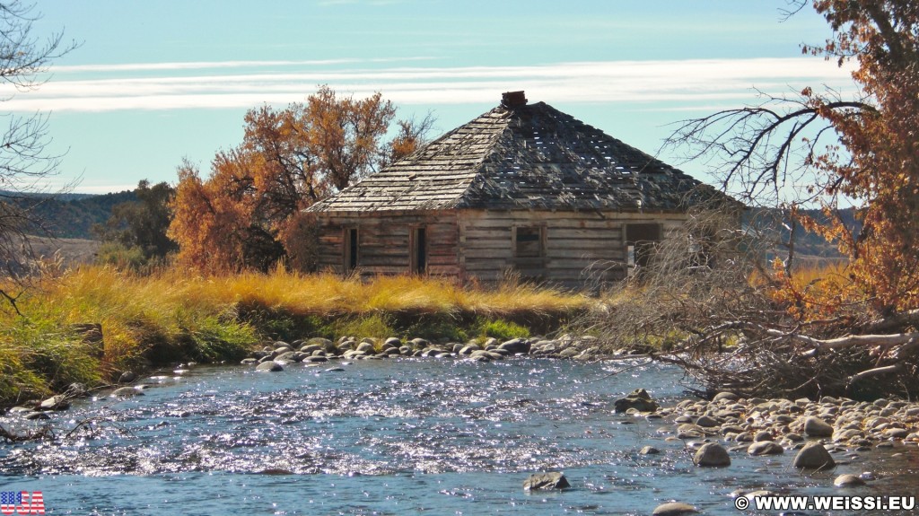 On the Road. Ten Sleep Creek - On the Road. - Gebäude, Haus, Landschaft, Bäume, Hütte, Fluss, Steine, Holzhaus, US Route 16, Bighorn Basin, Ten Sleep Creek, Bach, Holzhütte - (Ten Sleep, Wyoming, Vereinigte Staaten)