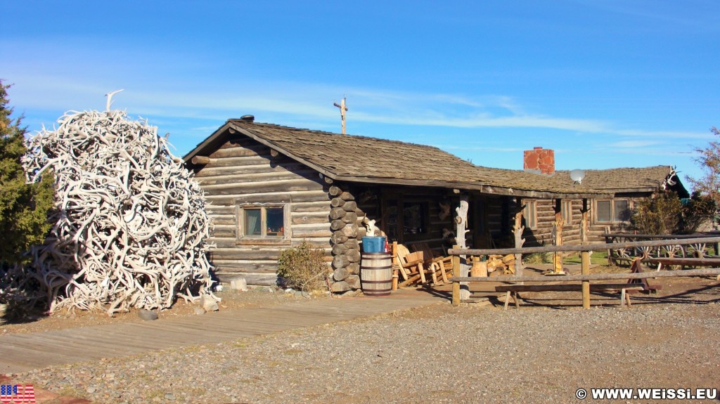 Old Trail Town. Old Trail Town - Museum of the Old West. - Gebäude, Zaun, Holzhaus, Holzhütte, Wild West, Old Trail Town, Museum of the Old West, Wilder Westen, Räder, Wagenräder, Elchgeweih, Geweih - (Cody, Wyoming, Vereinigte Staaten)