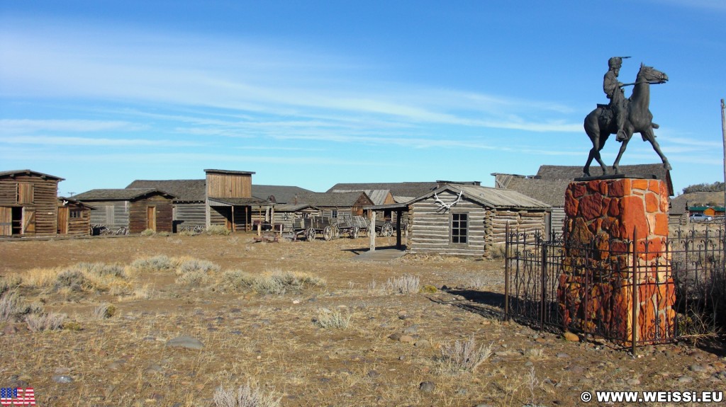 Old Trail Town. Old Trail Town - Museum of the Old West. - Gebäude, Statue, Holzhaus, Holzhütte, Wild West, Old Trail Town, Museum of the Old West, Wilder Westen, Liver-Eating Johnson - (Cody, Wyoming, Vereinigte Staaten)