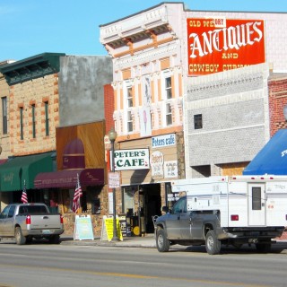 Main Street Cody. Main Street - Cody. - Gebäude, Häuser, Haus, Rattlesnake Mountain, Sheridan Ave, Main Street, Peter's Cafe & Bakery, Herself Boutique, Proud Cut Saloon, All That Glitters, Open Range Images, Fine Art Photography Gallery - (Cody, Wyoming, Vereinigte Staaten)