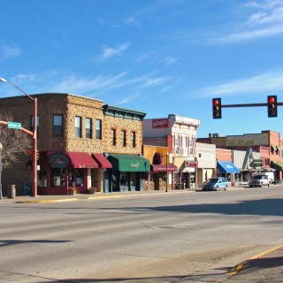 Main Street Cody. - Gebäude, Häuser, Haus, Sheridan Ave, Main Street, Peter's Cafe & Bakery, Herself Boutique, Proud Cut Saloon, All That Glitters, Open Range Images, Fine Art Photography Gallery - (Cody, Wyoming, Vereinigte Staaten)