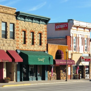Main Street Cody. - Gebäude, Häuser, Haus, Sheridan Ave, Main Street, Peter's Cafe & Bakery, Herself Boutique, Proud Cut Saloon, All That Glitters, Open Range Images, Fine Art Photography Gallery - (Cody, Wyoming, Vereinigte Staaten)
