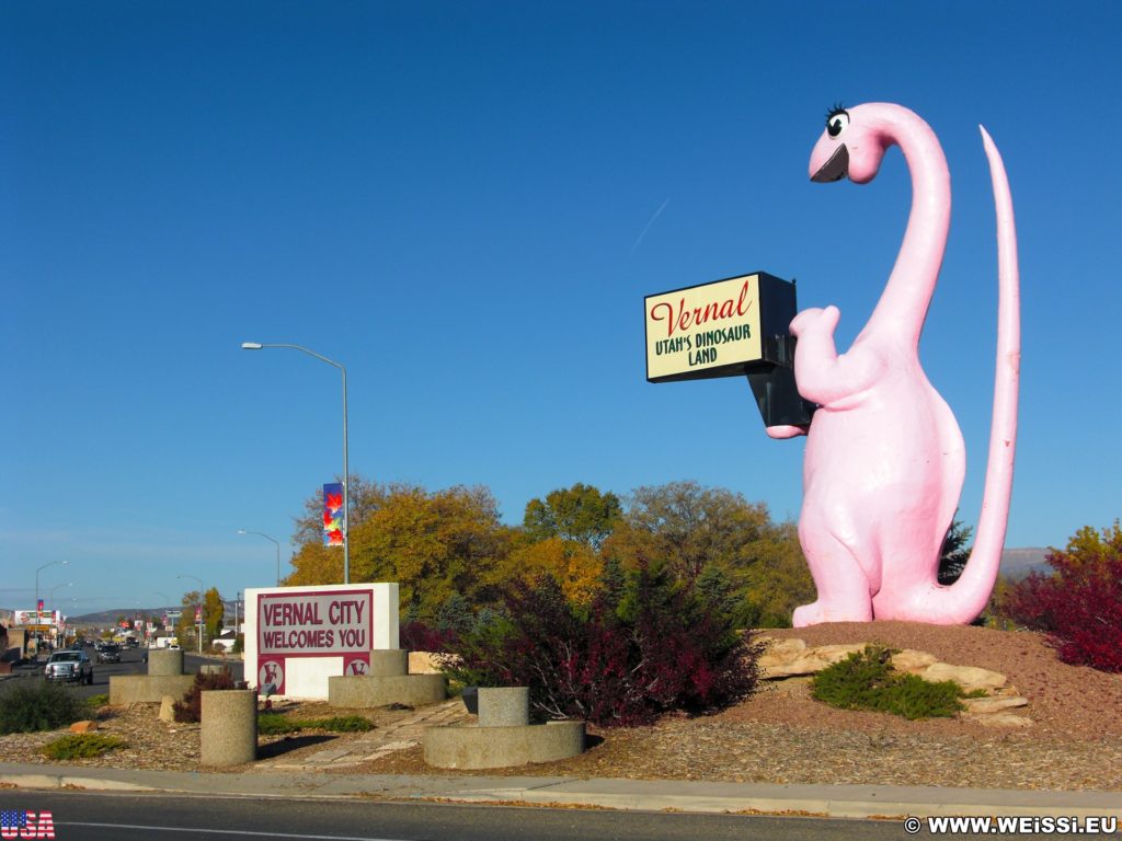 Vernal - Dinoland. Dinah the Pink Dinosaur ist eine Statue aus Fiberglas und gleichzeit ein Willkommensschild an der Osteinfahrt in Vernal. Die Skulptur wiegt 1905 kg.. - Tier, Skulptur, Statue, Dinosaurier, Dinah the Pink Dinosaur, Pink - (Vernal, Utah, Vereinigte Staaten)