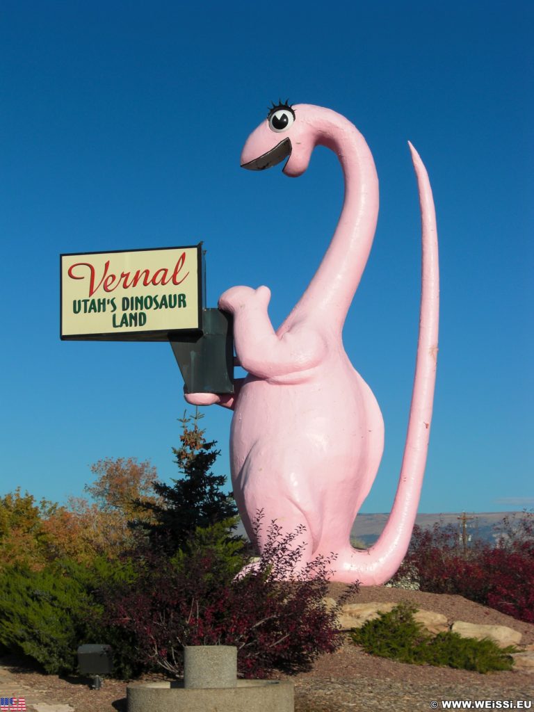 Vernal - Dinoland. Dinah the Pink Dinosaur ist eine Statue aus Fiberglas und gleichzeit ein Willkommensschild an der Osteinfahrt in Vernal. Die Skulptur wiegt 1905 kg.. - Tier, Skulptur, Statue, Dinosaurier, Dinah the Pink Dinosaur, Pink - (Vernal, Utah, Vereinigte Staaten)