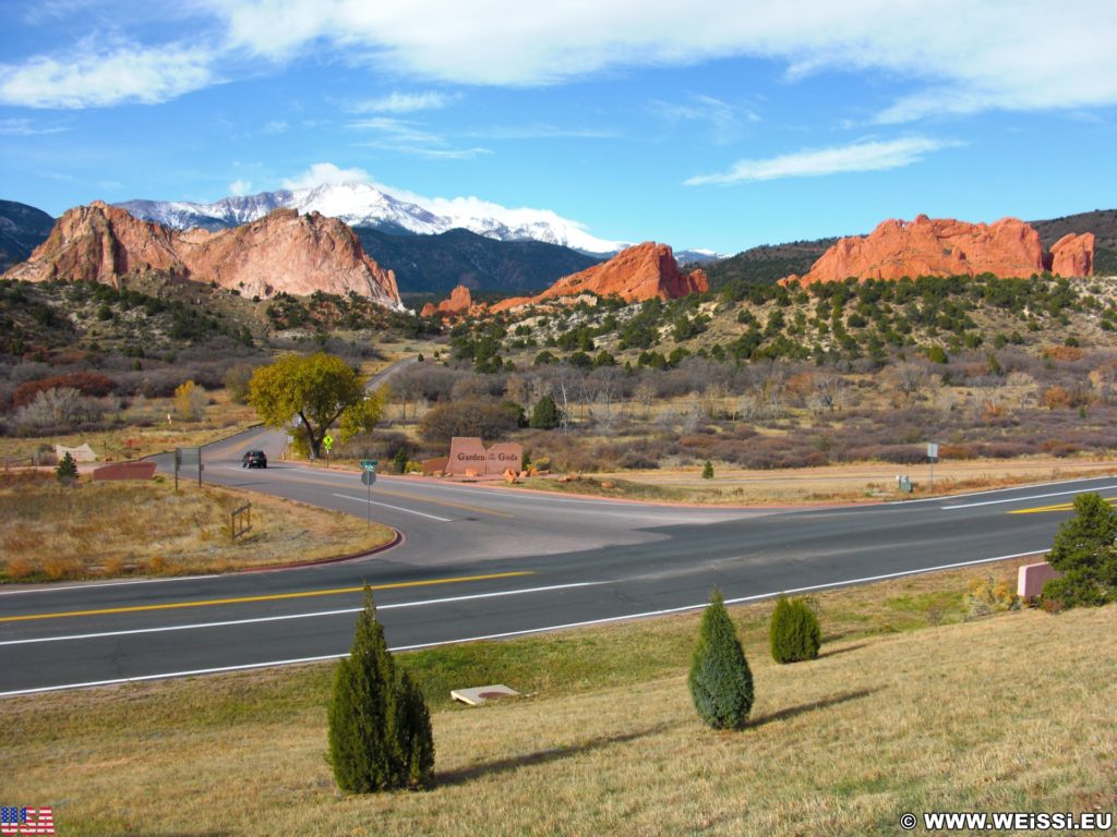 Garden of the Gods. Aussicht vom Besucherzentrum des Garden of the Gods Park. Im Hintergrund sieht man den schneebedeckten Gipfel des Pikes Peak auf den das bekannte Bergrennen Pikes Peak International Hill Climb oder auch Race to the Clouds genannt, ausgetragen wird. Die rötlich gefärbten Sandsteinformationen im Vordergrund sind Kindergarten-, South Gateway- und North Gateway Rock (v.l.n.r).. - Sehenswürdigkeit, Landschaft, Panorama, Sandstein, Sandsteinformationen, Park, Ausflugsziel, Garten der Götter, Naturpark, sehenswert, Kindergarten Rock, North Gateway Rock, Pikes Peak, South Gateway Rock - (Glen Eyrie, Colorado Springs, Colorado, Vereinigte Staaten)