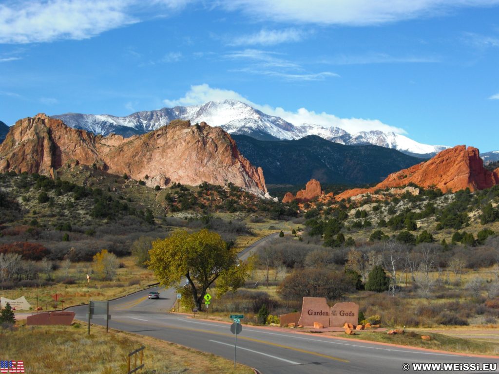 Garden of the Gods. Aussicht vom Besucherzentrum des Garden of the Gods Park. Im Hintergrund sieht man den schneebedeckten Gipfel des Pikes Peak auf den das bekannte Bergrennen Pikes Peak International Hill Climb oder auch Race to the Clouds genannt, ausgetragen wird. Die rötlich gefärbten Sandsteinformationen im Vordergrund sind Kindergarten- und South Gateway Rock (v.l.n.r).. - Sehenswürdigkeit, Landschaft, Panorama, Sandstein, Sandsteinformationen, Park, Ausflugsziel, Garten der Götter, Naturpark, sehenswert, Kindergarten Rock, Pikes Peak, South Gateway Rock - (Glen Eyrie, Colorado Springs, Colorado, Vereinigte Staaten)