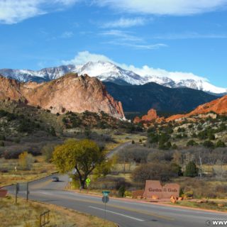 Garden of the Gods. Aussicht vom Besucherzentrum des Garden of the Gods Park. Im Hintergrund sieht man den schneebedeckten Gipfel des Pikes Peak auf den das bekannte Bergrennen Pikes Peak International Hill Climb oder auch Race to the Clouds genannt, ausgetragen wird. Die rötlich gefärbten Sandsteinformationen im Vordergrund sind Kindergarten- und South Gateway Rock (v.l.n.r).. - Sehenswürdigkeit, Landschaft, Panorama, Sandstein, Sandsteinformationen, Park, Ausflugsziel, Garten der Götter, Naturpark, sehenswert, Kindergarten Rock, Pikes Peak, South Gateway Rock - (Glen Eyrie, Colorado Springs, Colorado, Vereinigte Staaten)